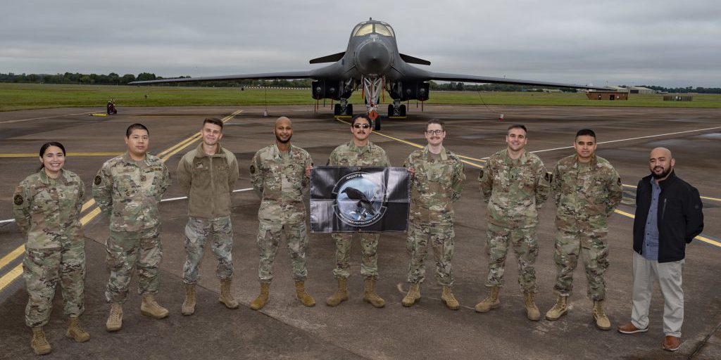 Defensive cyber network and host operators assigned to the 800th Cyber Protection Team, pose in front of a 9th Expeditionary Bomb Squadron B-1B Lancer, at RAF Fairford, United Kingdom, Oct. 8, 2021. The 800th CPT, Joint Force Headquarters Cyber- Air Force, is supporting the 9th Expeditionary Bomb Squadron during a Bomber Task Force Europe deployment by hunting and hardening systems on the B-1 to ensure components were free of any adversary activity. (U.S. Air Force photo by Senior Airman Colin Hollowell)